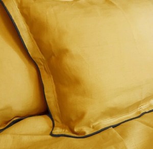 Taie d'oreiller en lin lavé jaune style bohème bordée d'un passepoil gris anthracite